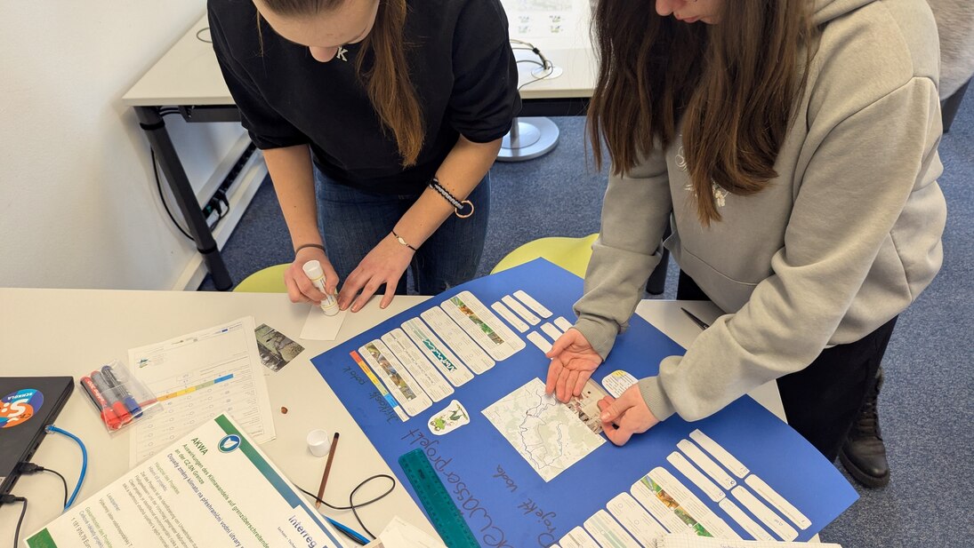 Deutsche und tschechische Kinder gestalten gemeinsam ein Poster über die Ergebnisse des Gewässerprojektes