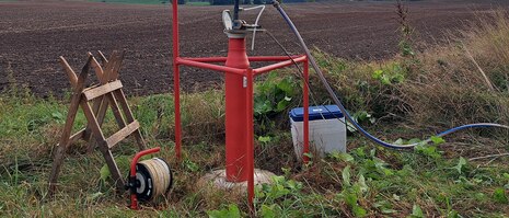 Messung an einer Grundwassermesstelle an einem Feld